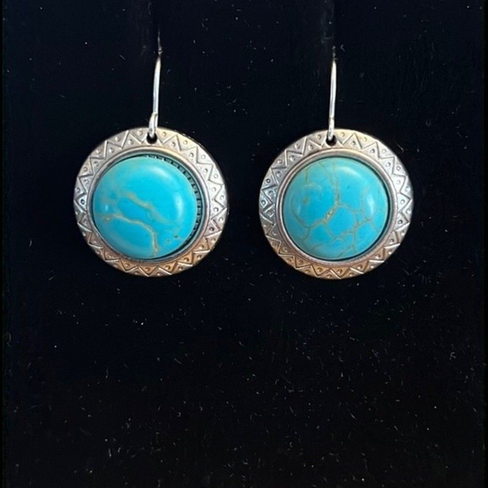 Handcrafted silver tone earrings with an turquoise colored stone.